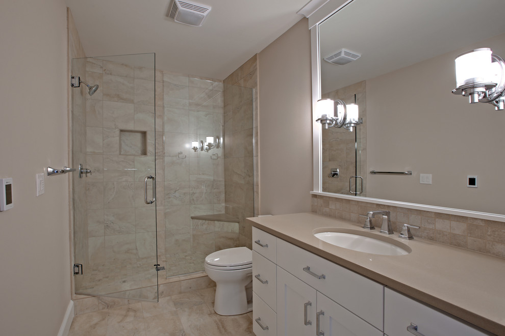 Design ideas for a mid-sized contemporary master bathroom with shaker cabinets, white cabinets, a two-piece toilet, gray tile, porcelain tile, beige walls, porcelain floors, an undermount sink and engineered quartz benchtops.