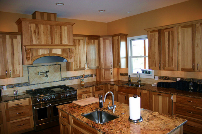 Mid-sized mountain style u-shaped dark wood floor and brown floor eat-in kitchen photo with shaker cabinets, medium tone wood cabinets, granite countertops, beige backsplash, ceramic backsplash, stainless steel appliances and two islands