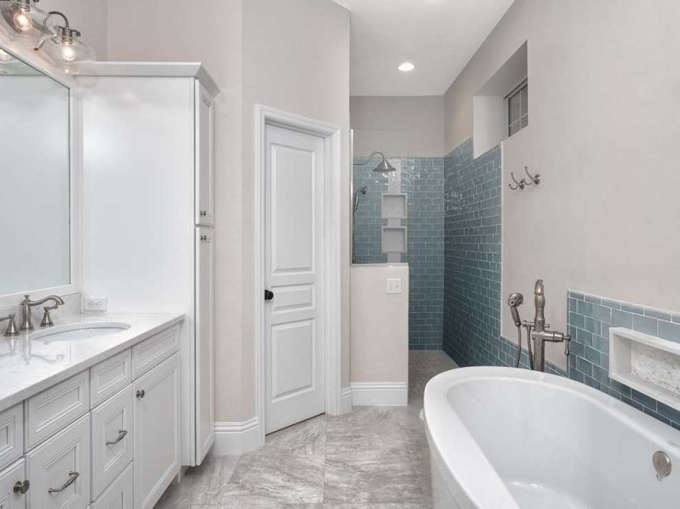 Klassisk inredning av ett mellanstort vit vitt badrum med dusch, med luckor med upphöjd panel, vita skåp, ett fristående badkar, en öppen dusch, en toalettstol med hel cisternkåpa, vit kakel, vita väggar, ett nedsänkt handfat, granitbänkskiva, flerfärgat golv och med dusch som är öppen