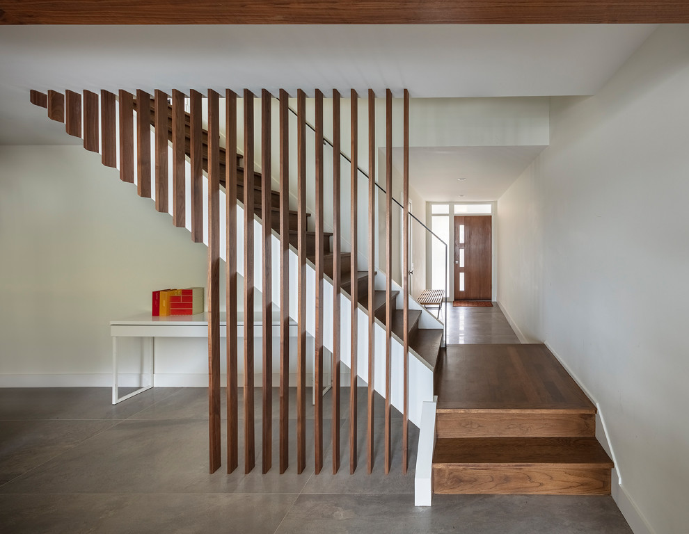 This is an example of a midcentury wood floating staircase in San Francisco with wood risers and wood railing.