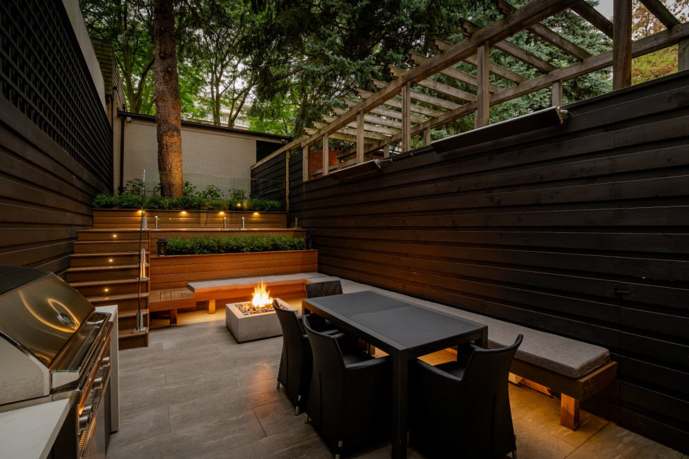 Small contemporary backyard patio in Toronto with an outdoor kitchen, concrete pavers and no cover.