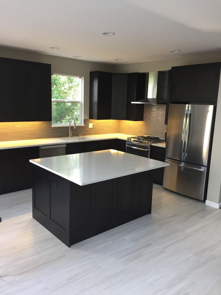 Enclosed kitchen - large transitional l-shaped laminate floor and beige floor enclosed kitchen idea in Denver with an undermount sink, shaker cabinets, dark wood cabinets, solid surface countertops, gray backsplash, glass tile backsplash, stainless steel appliances and an island