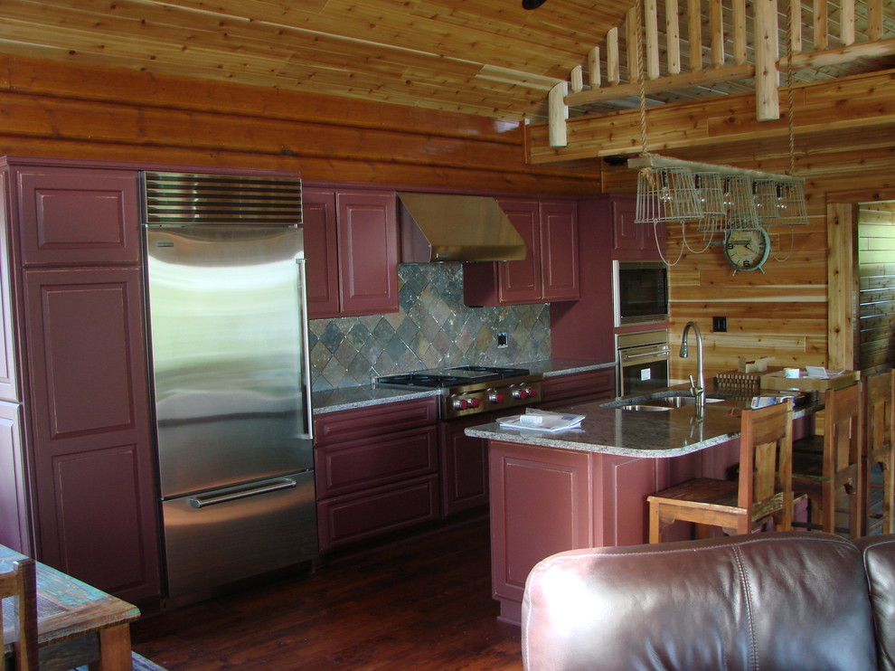 Open concept kitchen - mid-sized rustic single-wall medium tone wood floor and beige floor open concept kitchen idea with a double-bowl sink, raised-panel cabinets, red cabinets, granite countertops, gray backsplash, stone tile backsplash, stainless steel appliances and an island