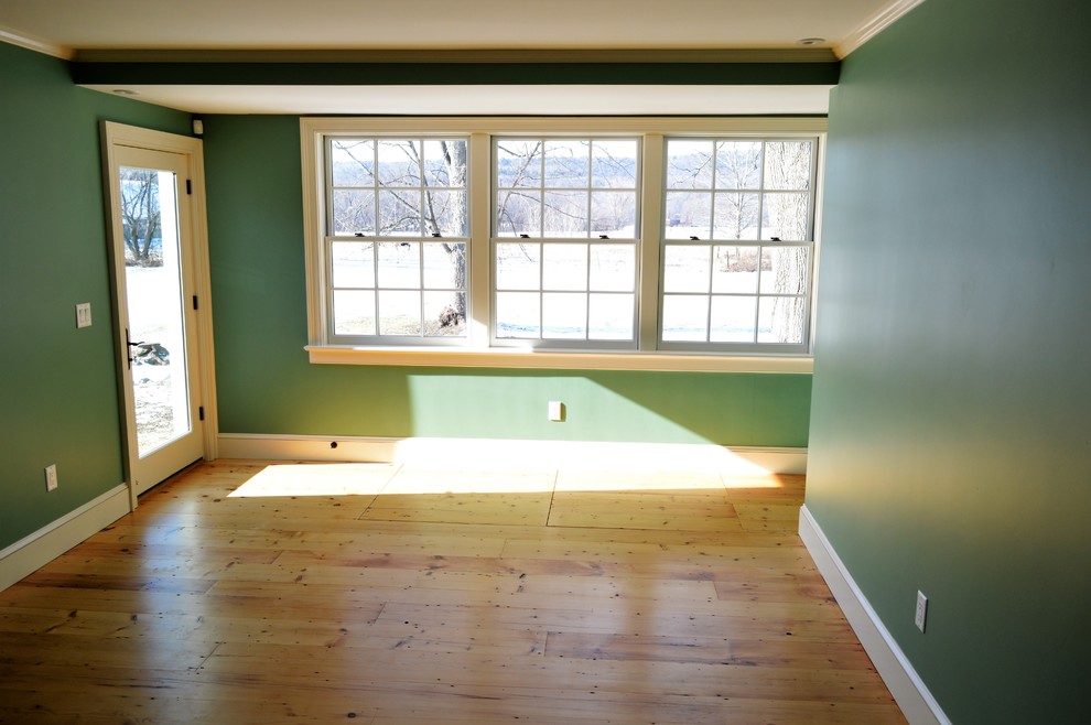 Photo of a mid-sized country enclosed living room in Boston with green walls, light hardwood floors, no fireplace and no tv.