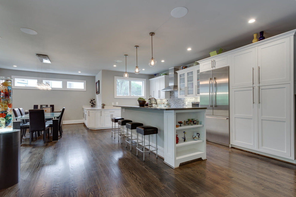 Example of a mid-sized transitional l-shaped dark wood floor eat-in kitchen design in Orange County with shaker cabinets, white cabinets, blue backsplash, matchstick tile backsplash, stainless steel appliances and an island
