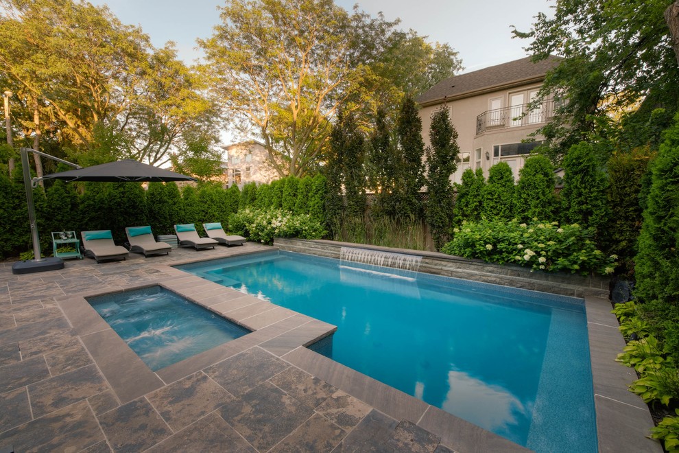 Example of a small transitional backyard stone and rectangular hot tub design in Toronto