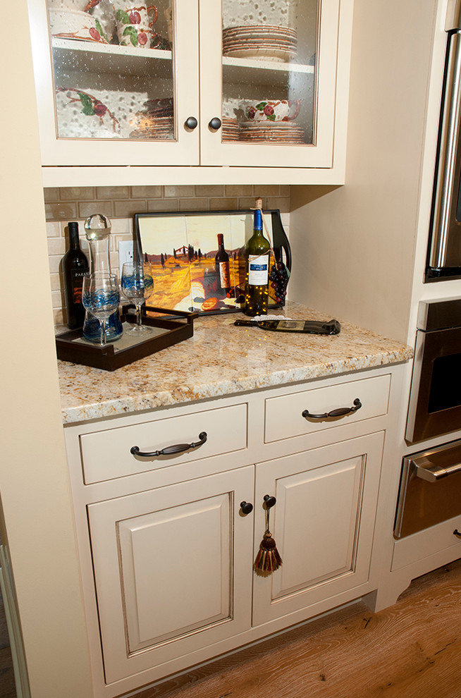 Small cottage galley light wood floor eat-in kitchen photo in Other with beaded inset cabinets, white cabinets, granite countertops, beige backsplash, ceramic backsplash, stainless steel appliances, a farmhouse sink and an island