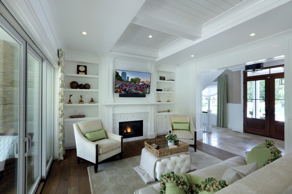 Photo of a mid-sized country open concept living room in Grand Rapids with white walls, medium hardwood floors, a standard fireplace, a tile fireplace surround, a wall-mounted tv and brown floor.