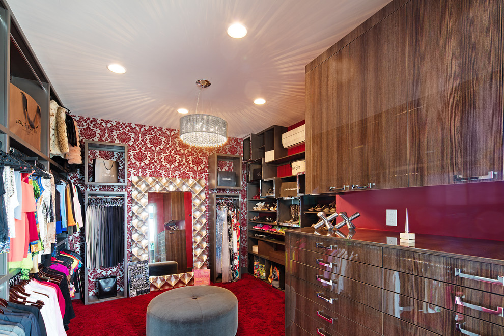 Photo of a large modern women's dressing room in Austin with flat-panel cabinets, medium wood cabinets and carpet.