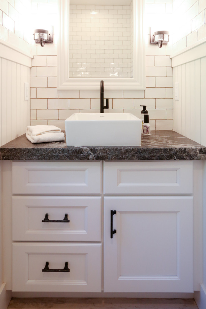 Inspiration for a mid-sized transitional master bathroom in Other with recessed-panel cabinets, white cabinets, an open shower, a two-piece toilet, white tile, subway tile, white walls, light hardwood floors, a vessel sink and soapstone benchtops.