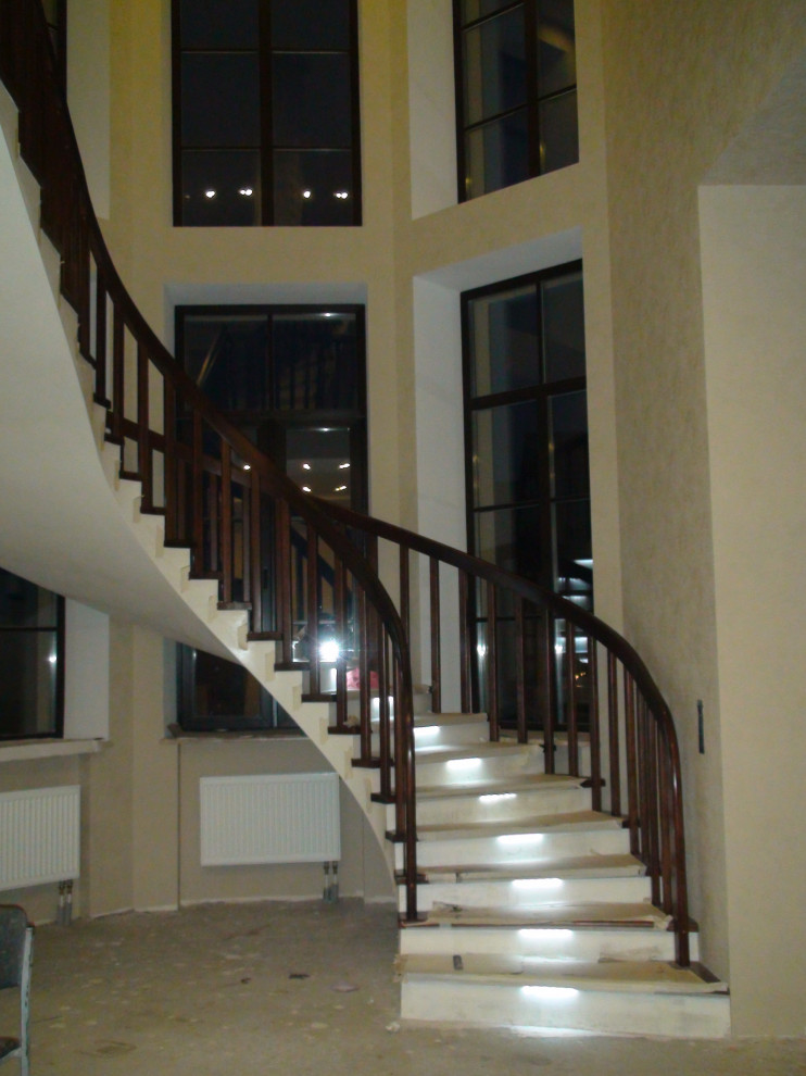 Идея дизайна: изогнутая бетонная лестница среднего размера в стиле кантри с бетонными ступенями, деревянными перилами и обоями на стенах