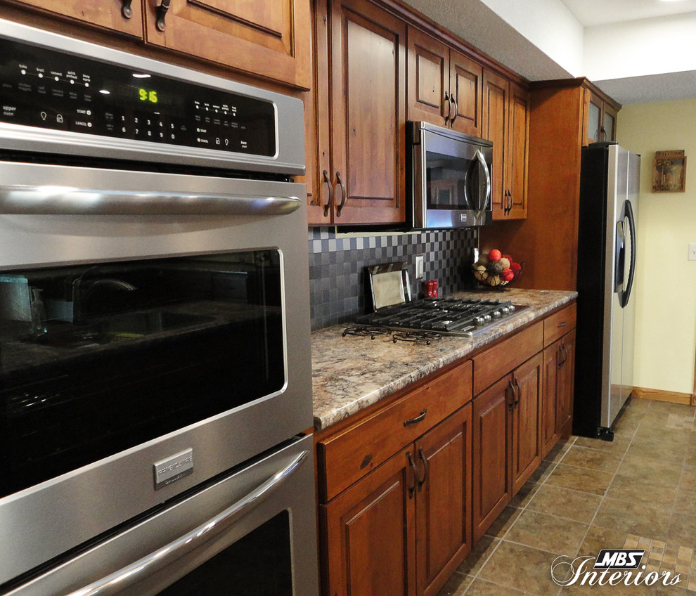 Eat-in kitchen - rustic eat-in kitchen idea with an undermount sink, medium tone wood cabinets, laminate countertops, gray backsplash, metal backsplash and stainless steel appliances
