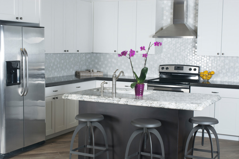 Eat-in kitchen - mid-sized transitional l-shaped porcelain tile and brown floor eat-in kitchen idea in Phoenix with an undermount sink, shaker cabinets, white cabinets, granite countertops, white backsplash, mosaic tile backsplash, stainless steel appliances and an island