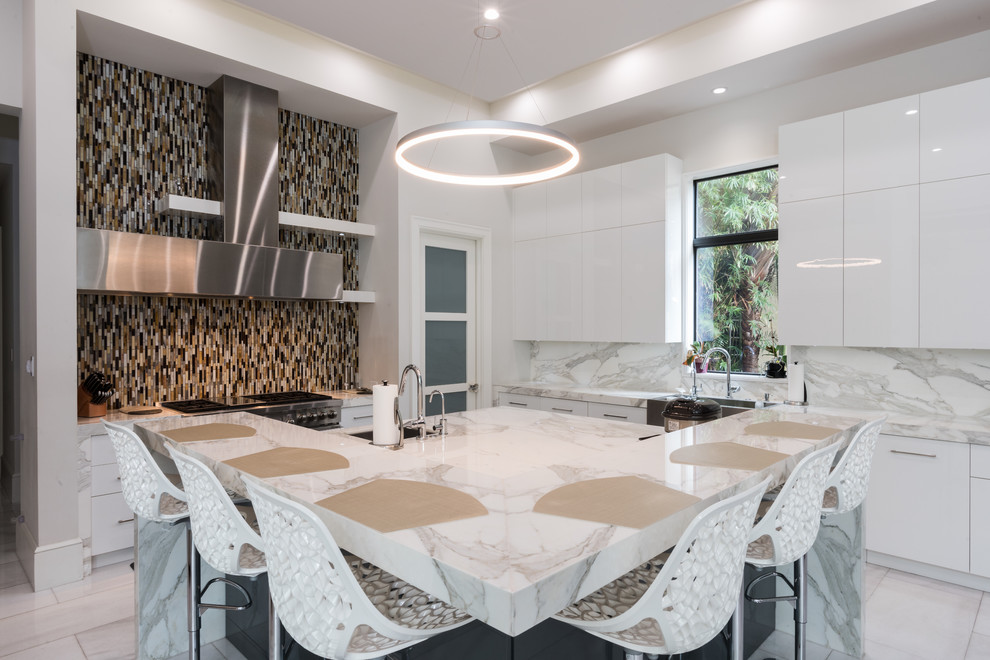 Mid-sized contemporary l-shaped open plan kitchen in Miami with flat-panel cabinets, white cabinets, marble benchtops, multi-coloured splashback, marble splashback, stainless steel appliances, marble floors, with island, a farmhouse sink and white floor.