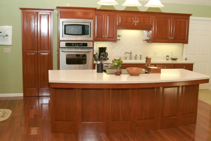 This is an example of a mid-sized traditional single-wall separate kitchen in Other with an undermount sink, raised-panel cabinets, dark wood cabinets, limestone benchtops, beige splashback, travertine splashback, stainless steel appliances, dark hardwood floors, with island and brown floor.
