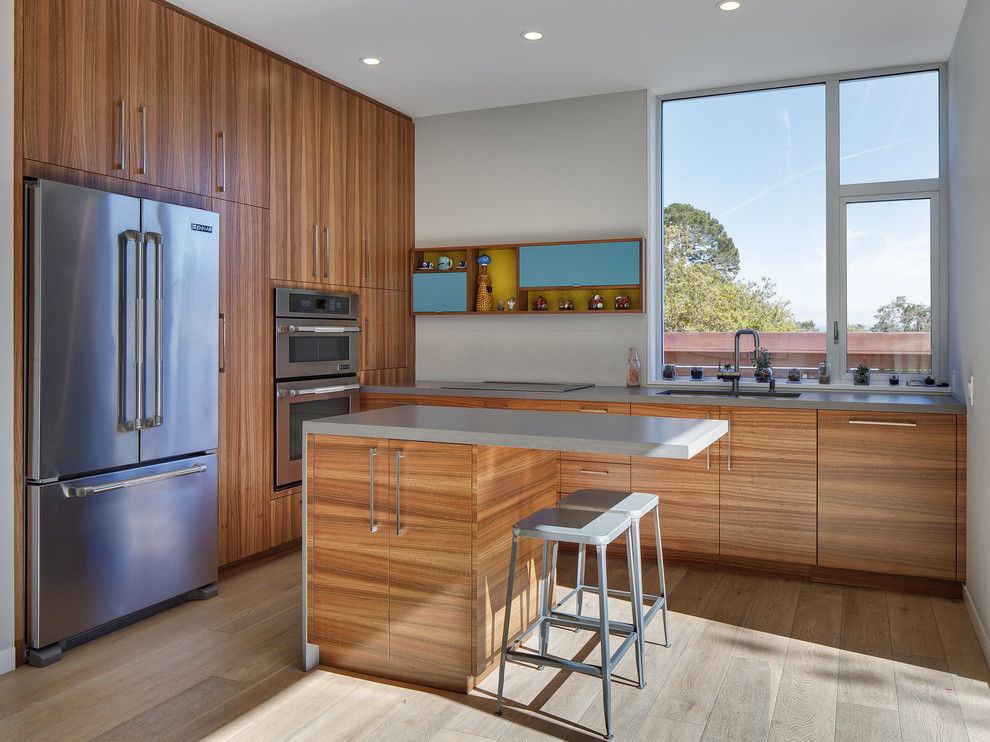 Photo of a contemporary kitchen in San Francisco with an undermount sink, flat-panel cabinets, medium wood cabinets, quartzite benchtops, stainless steel appliances, light hardwood floors and with island.
