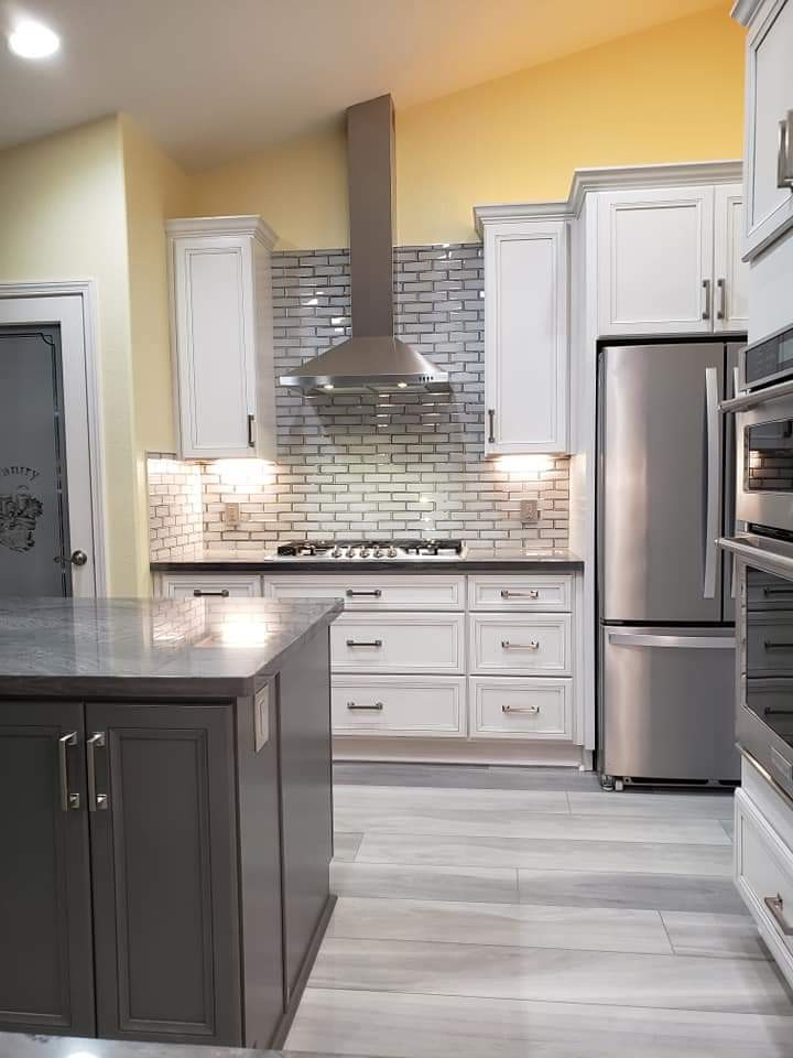 Example of a gray floor kitchen design with an undermount sink, quartzite countertops, glass tile backsplash, stainless steel appliances, an island and gray countertops