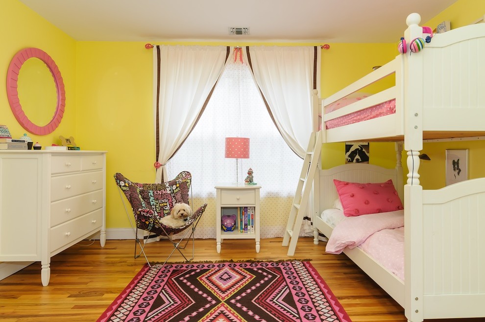 This is an example of a transitional kids' room in New York with yellow walls.