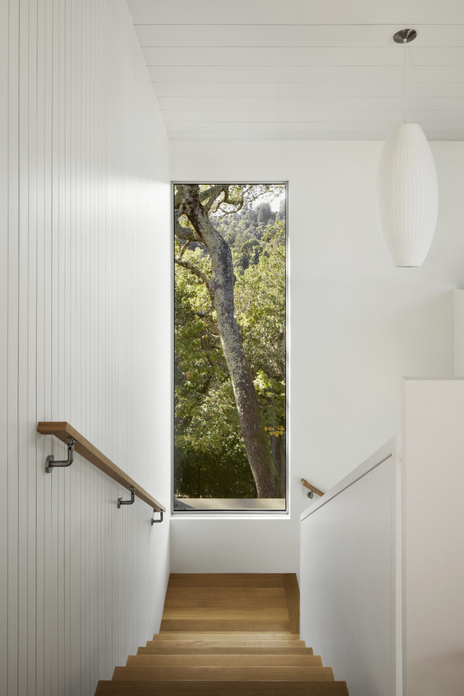 Источник вдохновения для домашнего уюта: огромная угловая деревянная лестница в стиле ретро с деревянными ступенями, деревянными перилами и панелями на части стены