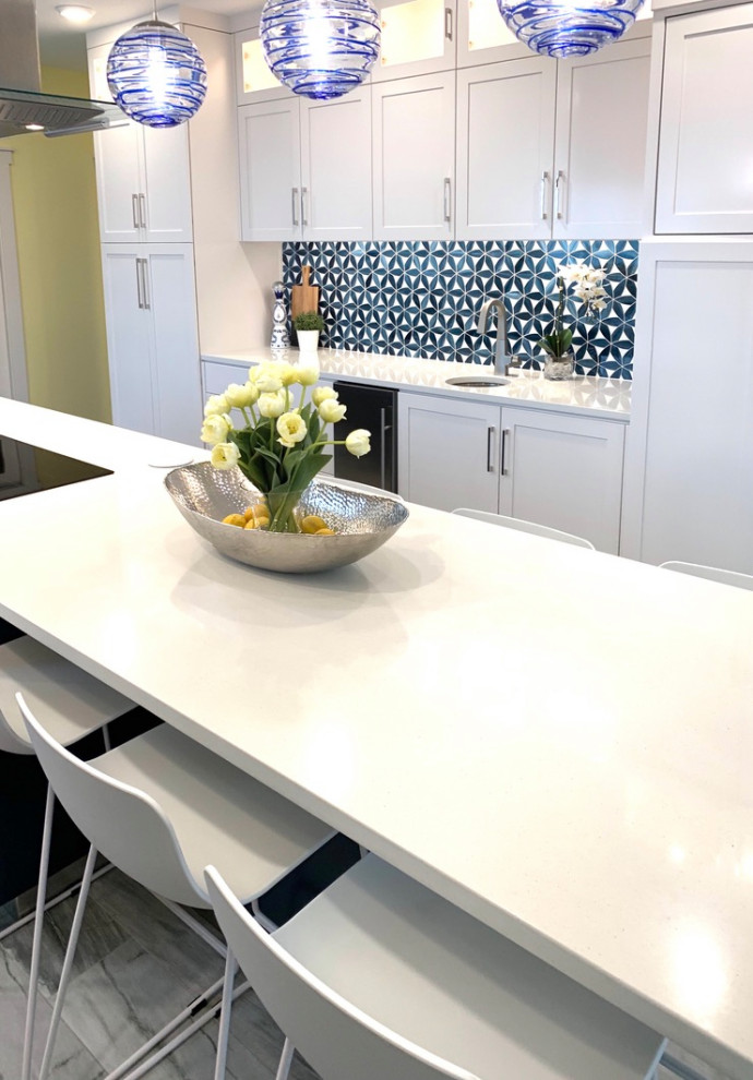Large modern u-shaped kitchen pantry in Other with a farmhouse sink, shaker cabinets, yellow cabinets, quartz benchtops, blue splashback, glass tile splashback, stainless steel appliances, porcelain floors, with island, grey floor and white benchtop.