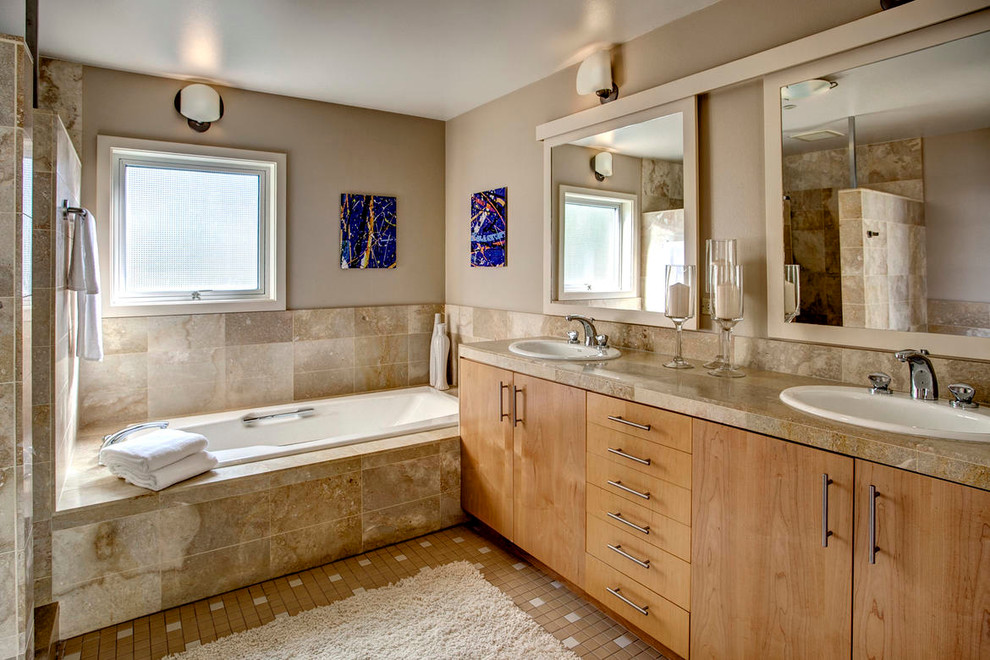 Design ideas for a contemporary bathroom in Seattle with a drop-in sink, flat-panel cabinets, medium wood cabinets, a drop-in tub, beige tile and beige walls.