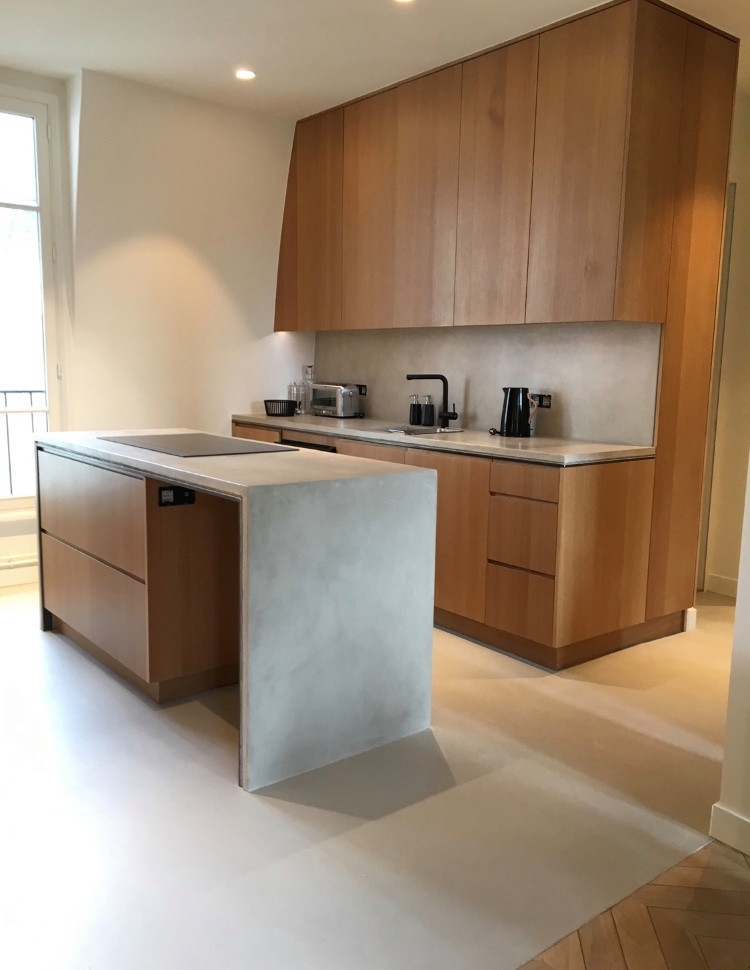 Exemple d'une cuisine ouverte parallèle et encastrable moderne de taille moyenne avec un placard à porte plane, un plan de travail en béton, une crédence grise, sol en béton ciré, îlot, un sol gris et un plan de travail gris.