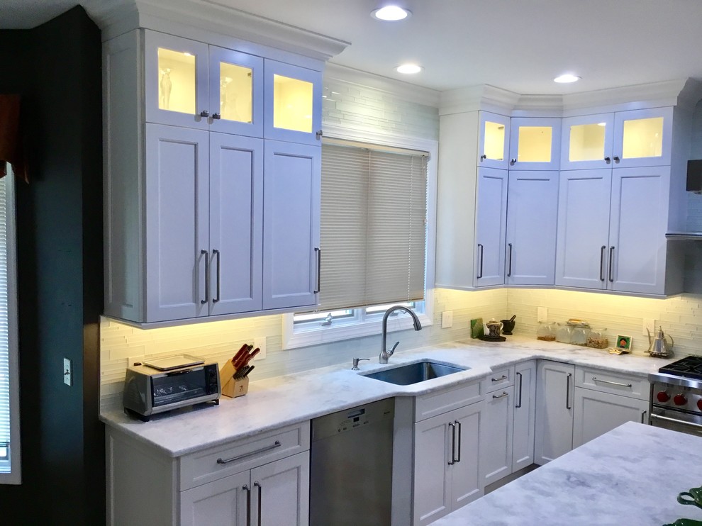 Large transitional u-shaped light wood floor and beige floor open concept kitchen photo in New York with an undermount sink, beaded inset cabinets, white cabinets, marble countertops, white backsplash, stainless steel appliances and an island
