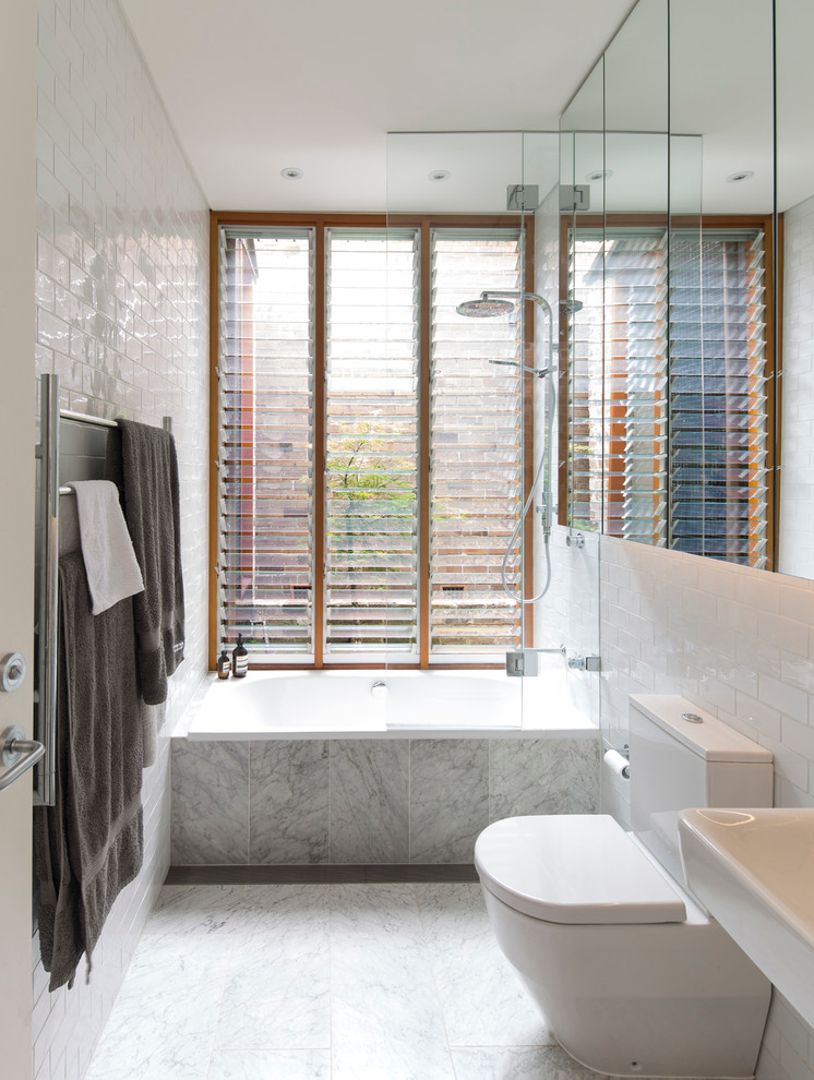 Inspiration for a mid-sized contemporary bathroom in Sydney with stone tile, a drop-in tub, a shower/bathtub combo, a two-piece toilet, white tile and an open shower.