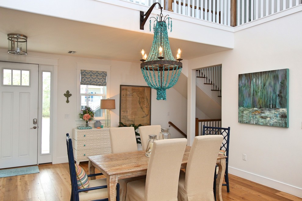 Large beach style dining room in Tampa with white walls, medium hardwood floors and brown floor.