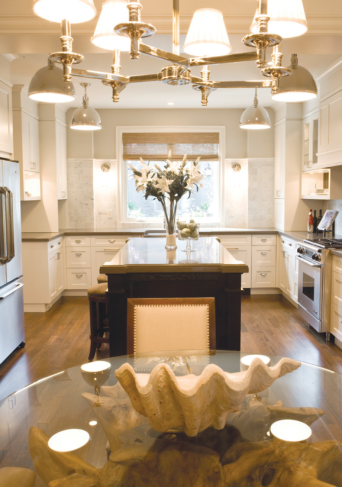 Kitchen - medium tone wood floor kitchen idea in Calgary with white cabinets, stainless steel appliances and an island