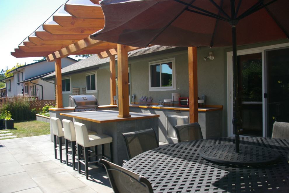 Moderne Pergola hinter dem Haus mit Outdoor-Küche und Betonboden in Sonstige