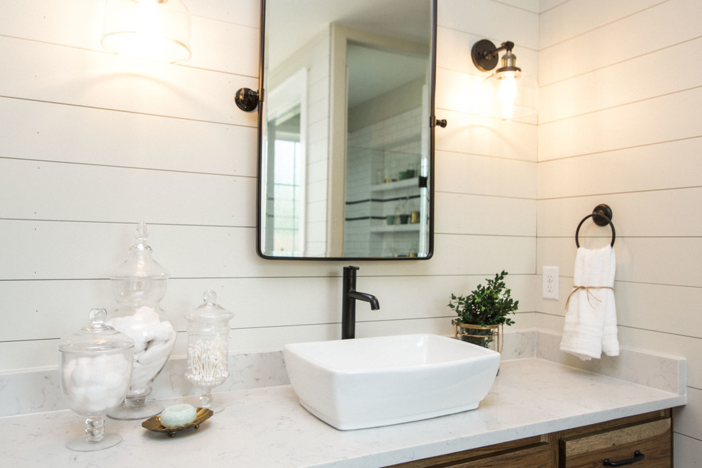 Photo of a large country master bathroom in Austin with flat-panel cabinets, medium wood cabinets, a corner tub, white tile, ceramic tile, white walls, ceramic floors, black floor and white benchtops.