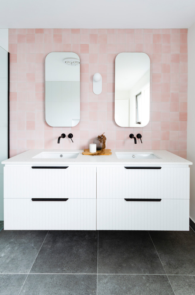 This is an example of a large contemporary master bathroom in Melbourne with beaded inset cabinets, white cabinets, a freestanding tub, a corner shower, a one-piece toilet, pink tile, porcelain tile, pink walls, porcelain floors, an undermount sink, engineered quartz benchtops, grey floor, a sliding shower screen, white benchtops, a double vanity and a floating vanity.