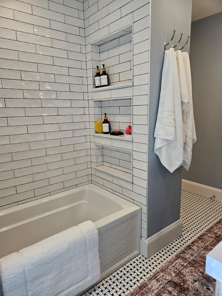 This is an example of a mid-sized arts and crafts master bathroom in New York with flat-panel cabinets, dark wood cabinets, an alcove tub, a shower/bathtub combo, a one-piece toilet, white tile, ceramic tile, blue walls, porcelain floors, an undermount sink, engineered quartz benchtops, multi-coloured floor, a shower curtain, white benchtops, a niche, a double vanity and a freestanding vanity.