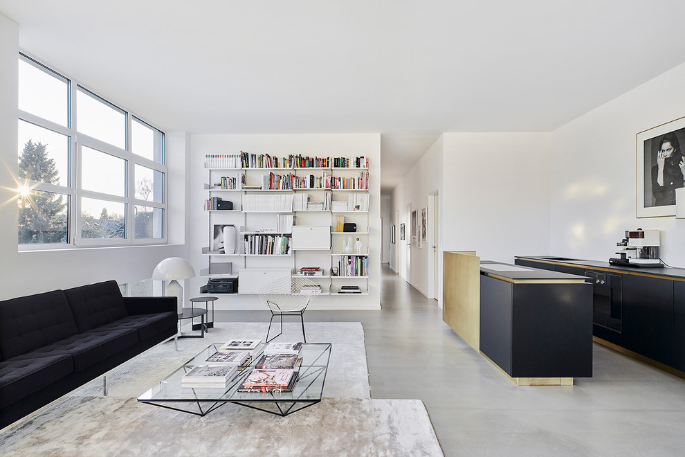 Large contemporary open concept living room in Cologne with white walls, concrete floors, no tv, grey floor, a library and no fireplace.