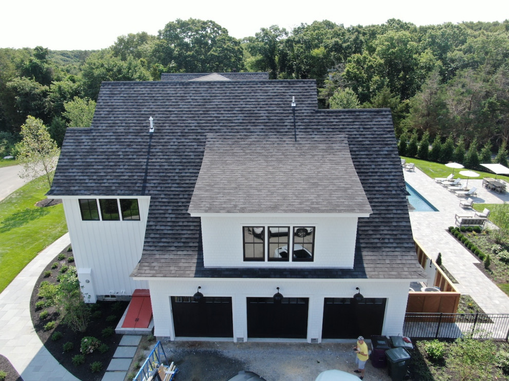 Geräumiges, Dreistöckiges Modernes Haus mit weißer Fassadenfarbe, Satteldach, Misch-Dachdeckung, schwarzem Dach und Wandpaneelen in Bridgeport