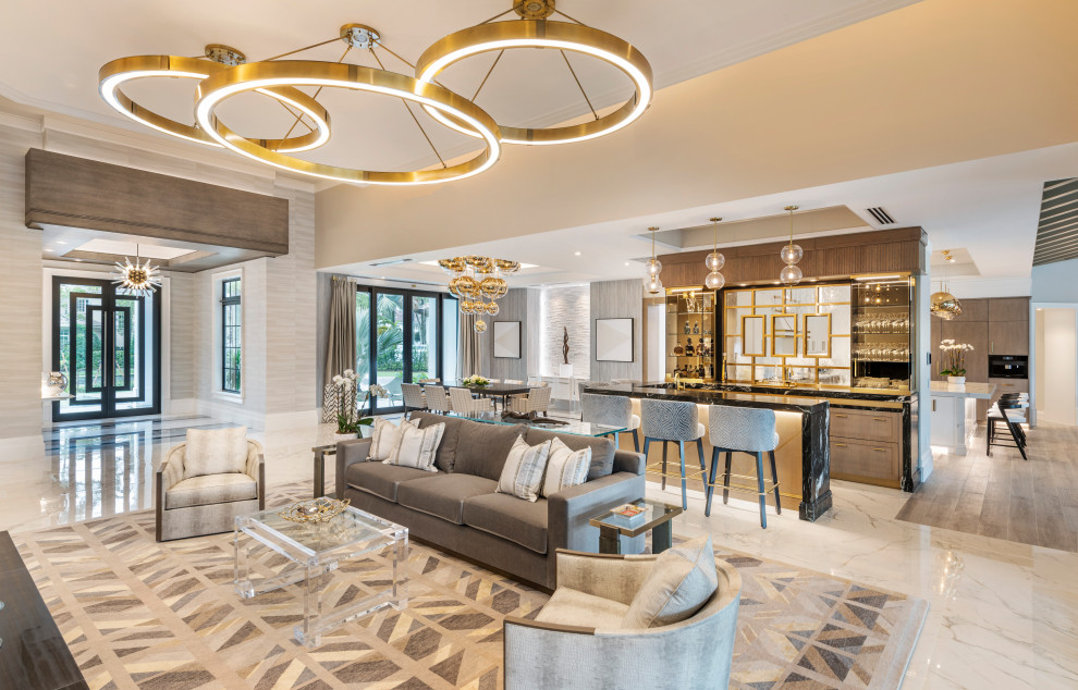 Expansive transitional living room in Miami with a home bar, beige walls, porcelain floors, a ribbon fireplace, a stone fireplace surround, white floor, wood and wallpaper.