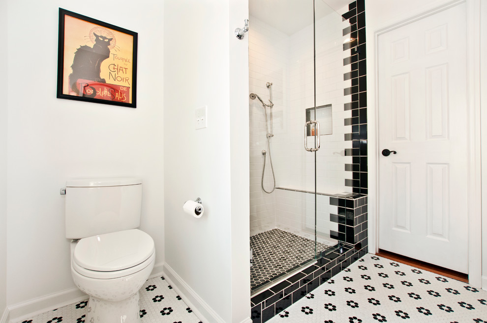 Photo of a traditional 3/4 bathroom in Nashville with a corner shower, a two-piece toilet, black and white tile, white walls and a hinged shower door.