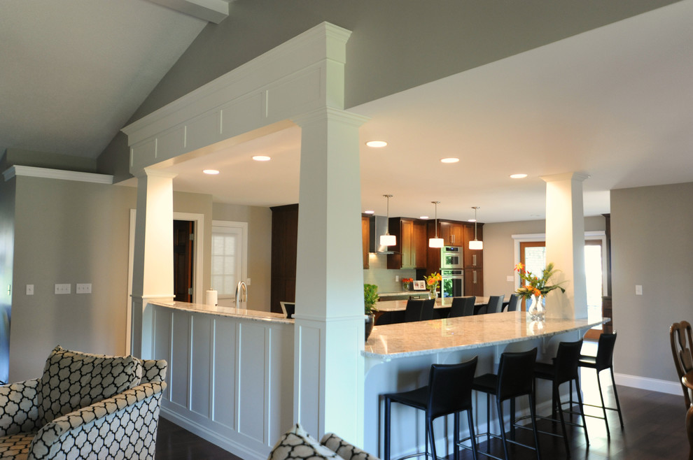 Huge transitional l-shaped ceramic tile open concept kitchen photo in Chicago with an undermount sink, shaker cabinets, medium tone wood cabinets, granite countertops, gray backsplash, glass tile backsplash, stainless steel appliances and an island
