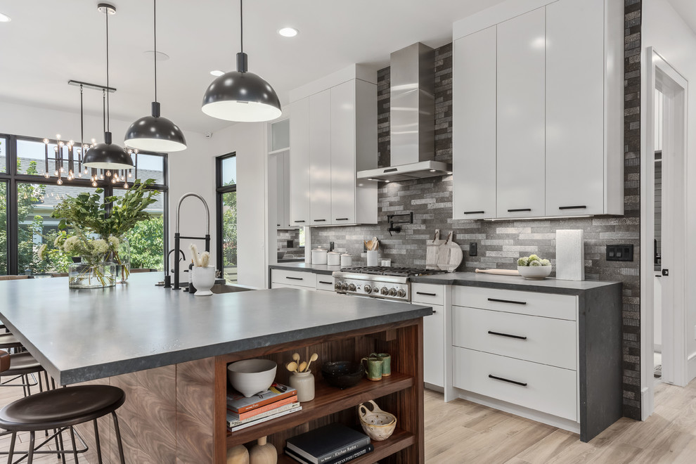 This is an example of a large contemporary l-shaped eat-in kitchen in Salt Lake City with a farmhouse sink, flat-panel cabinets, white cabinets, quartzite benchtops, grey splashback, stone tile splashback, stainless steel appliances, porcelain floors, with island, beige floor and grey benchtop.
