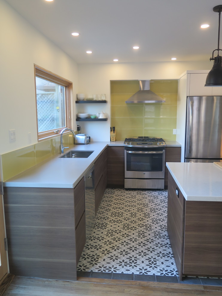 This is an example of a mid-sized midcentury l-shaped eat-in kitchen in Toronto with flat-panel cabinets, dark wood cabinets, quartz benchtops, yellow splashback, glass tile splashback, stainless steel appliances, ceramic floors, with island, multi-coloured floor and an undermount sink.