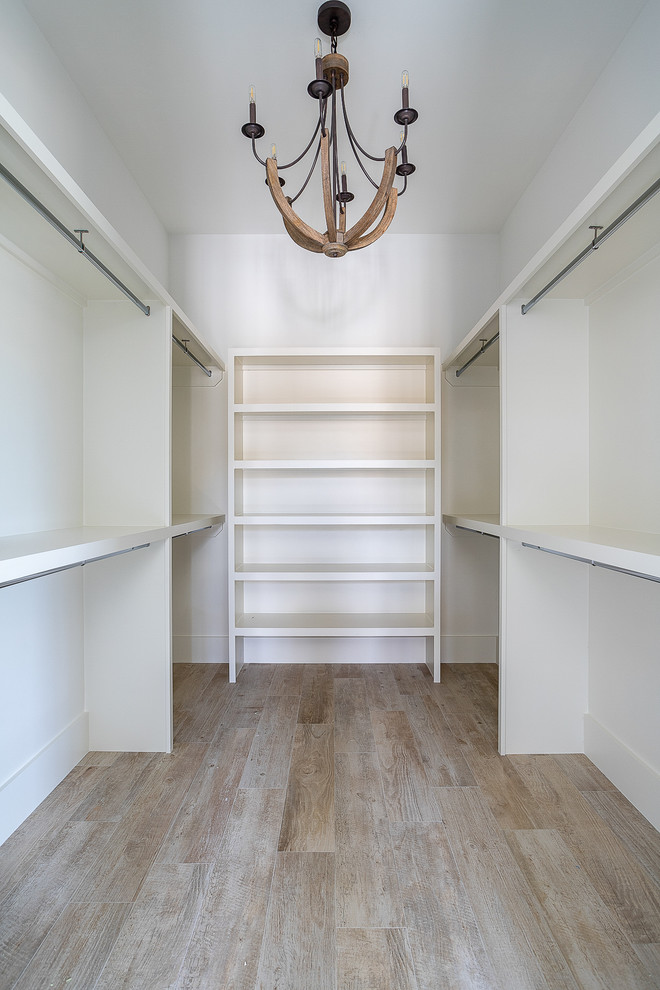 Inspiration for a large beach style walk-in wardrobe in Charleston with light hardwood floors and brown floor.