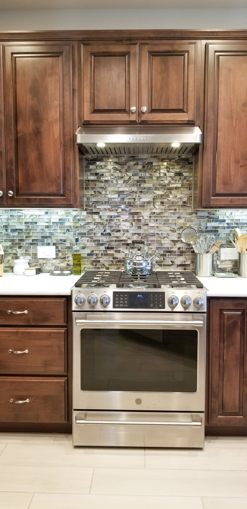 Design ideas for a modern single-wall eat-in kitchen in Salt Lake City with raised-panel cabinets, medium wood cabinets, blue splashback, ceramic splashback, stainless steel appliances, cement tiles, no island, beige floor and white benchtop.