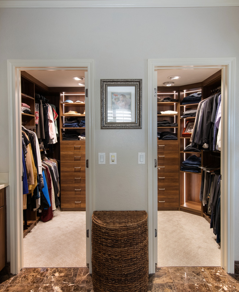 Exempel på ett mellanstort walk-in-closet för könsneutrala, med släta luckor, skåp i mellenmörkt trä, marmorgolv och beiget golv