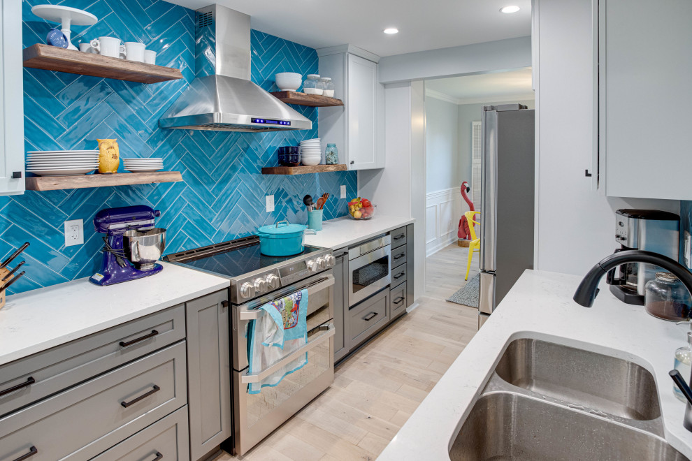 Inspiration for a mid-sized transitional galley kitchen remodel in DC Metro with an undermount sink, shaker cabinets, quartz countertops, blue backsplash, stainless steel appliances and no island