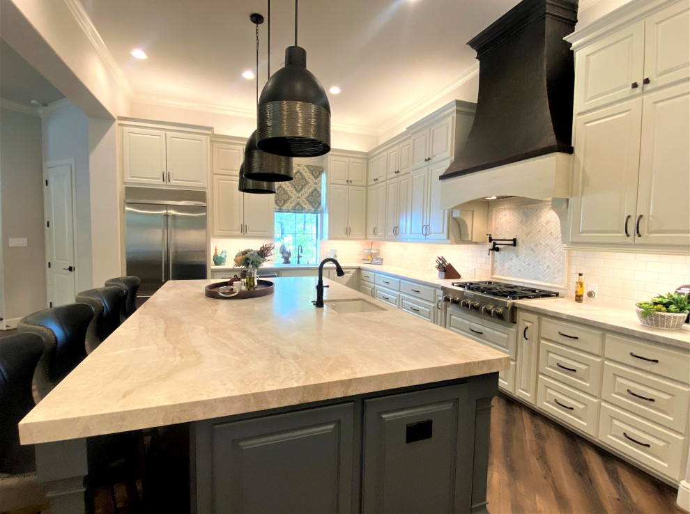 This is an example of a large transitional u-shaped eat-in kitchen in Houston with an undermount sink, raised-panel cabinets, white cabinets, quartzite benchtops, white splashback, stone tile splashback, stainless steel appliances, porcelain floors and with island.