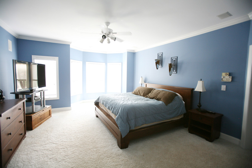 Photo of an expansive transitional master bedroom in Charlotte with blue walls, carpet and no fireplace.