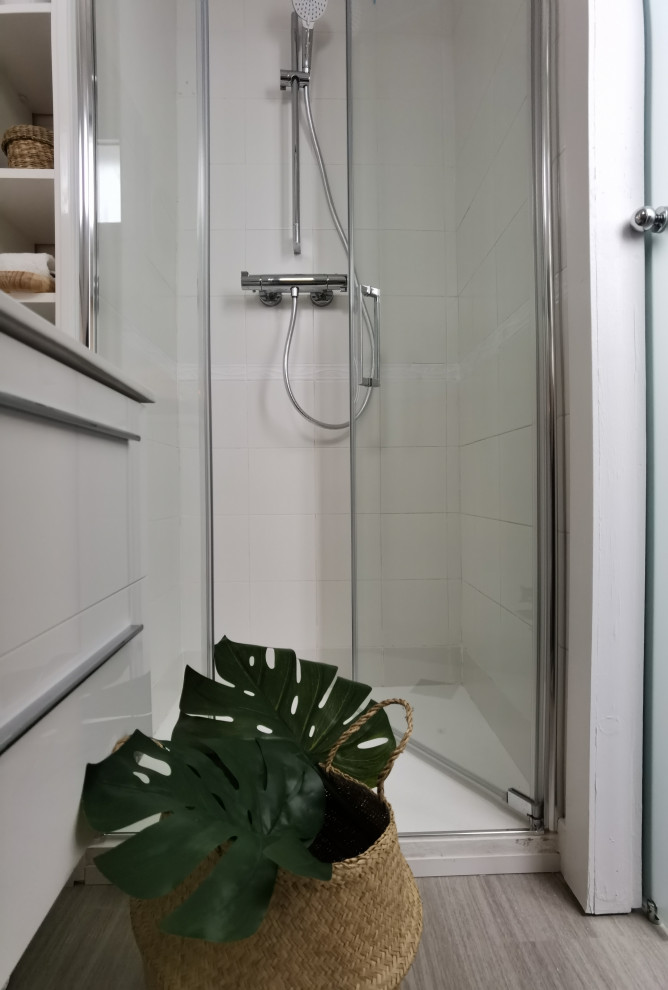 Foto på ett litet 50 tals badrum med dusch, med öppna hyllor, vita skåp, våtrum, vit kakel, ljust trägolv, grått golv och dusch med gångjärnsdörr