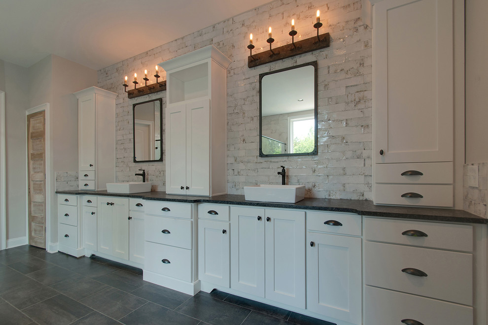 Large transitional master bathroom in Nashville with shaker cabinets, white cabinets, an open shower, a one-piece toilet, white tile, ceramic tile, grey walls, ceramic floors, grey floor, black benchtops, a freestanding tub, a vessel sink and a hinged shower door.