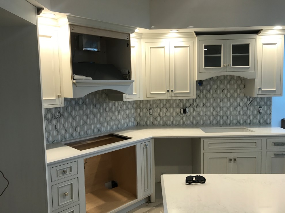 Enclosed kitchen - large modern single-wall enclosed kitchen idea with a double-bowl sink, marble backsplash and stainless steel appliances